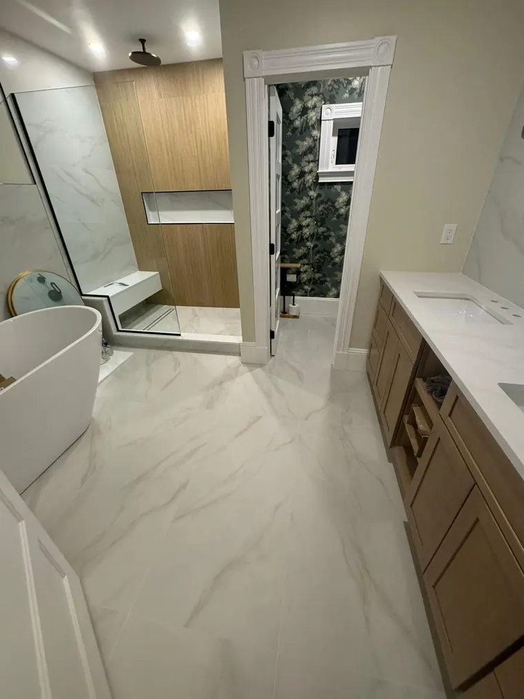 Freestanding tub on a marble look porcelain floor in a finished bathroom remodel
